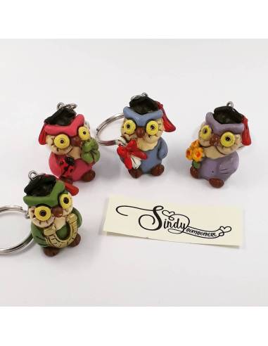 Bomboniera portachiavi raffiguranti dei gufi colorati in quattro colori con fiori staffa pergamena e quadrifoglio