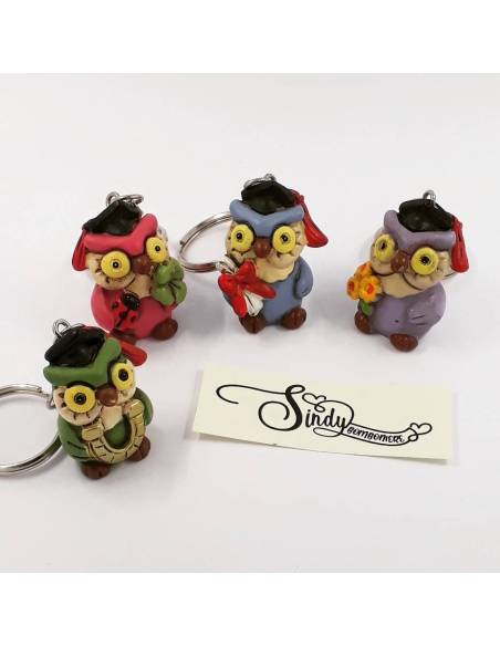 Bomboniera portachiavi raffiguranti dei gufi colorati in quattro colori con fiori staffa pergamena e quadrifoglio