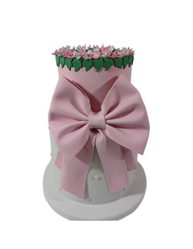 Torta finta scenografica con fiocco rosa e decoro floreale